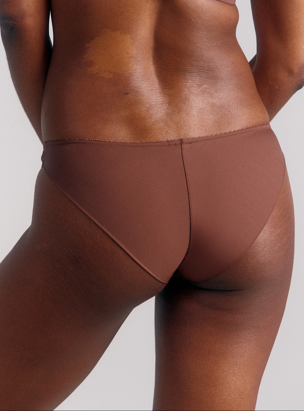 Culotte en dentelle légère et microfibre porté en vue de dos, idéal pour les carnations mates à foncées - Cutis Paris.
